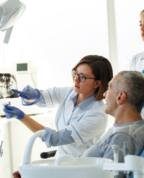 A man seeing a dentist and reviewing his X-rays