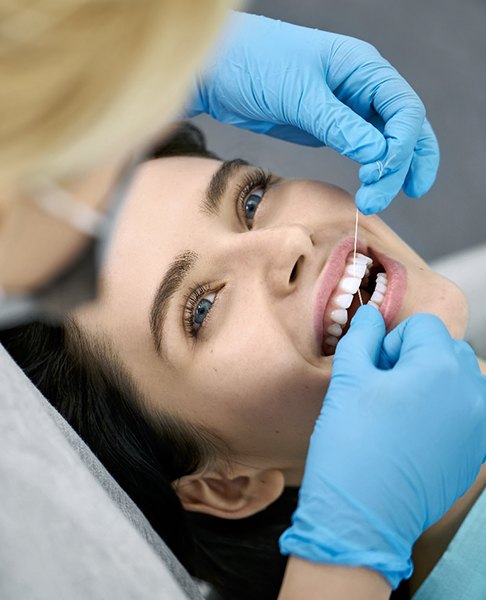 Female patient having her teeth flossed