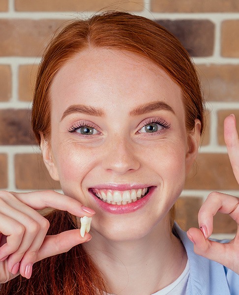 Someone holding an extracted tooth