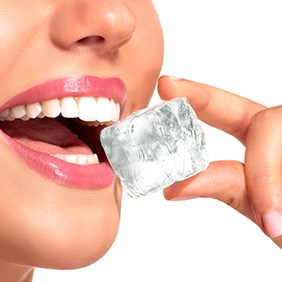 Patient in Glendale biting ice with dental implants