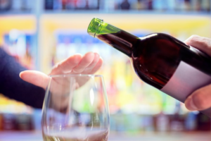 Close up of hand stopping someone from pouring alcohol into their glass