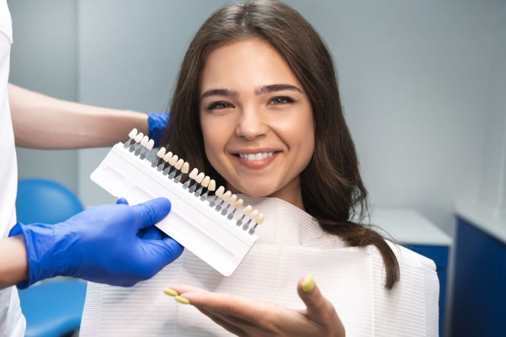 A woman in a dental chair choosing her shade of veneers.