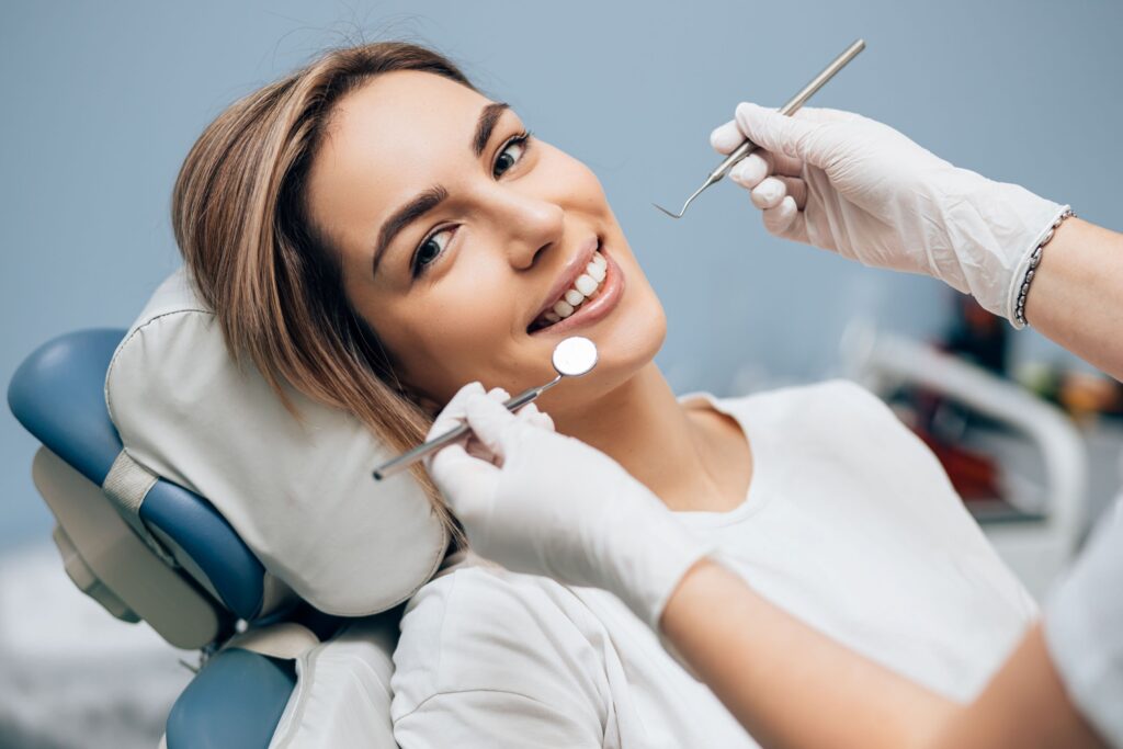 Woman in white t-shirt about to undergo dental exam and cleaning